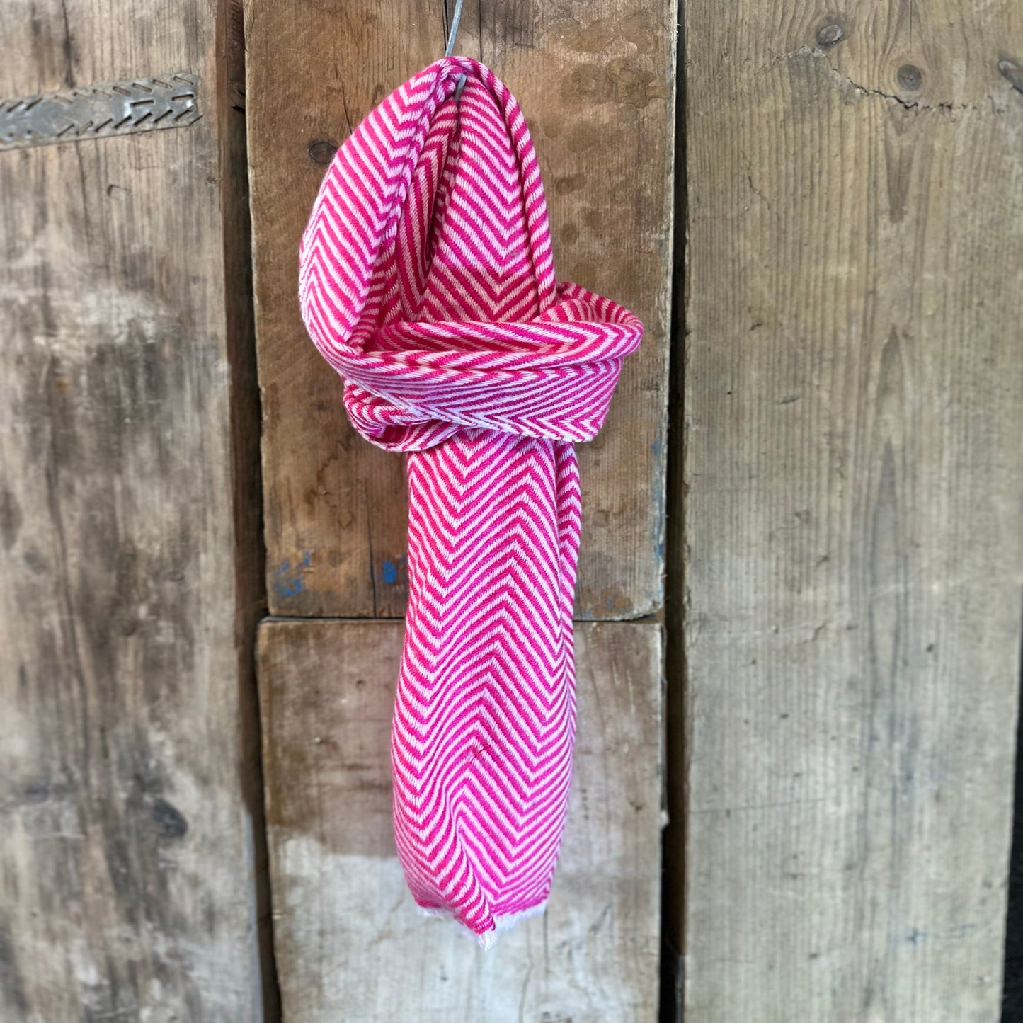Pink and white scarf on wooden background
